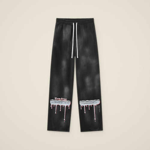 Digital preview: the High Water sweatpants laid flat, front view, with the chrome flood line and drips across both lower legs. The print was added digitally to a photo of the blank pants.