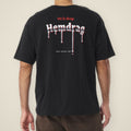 Digital preview: back view of a model wearing the black Let It Drag boxy tee. "let it drag" in red blackletter sits above the Hemdrag logo in chrome blackletter, with drips running off the letters and a small Drop 01 line beside the longest drip. The print was added digitally to a photo of the blank tee.