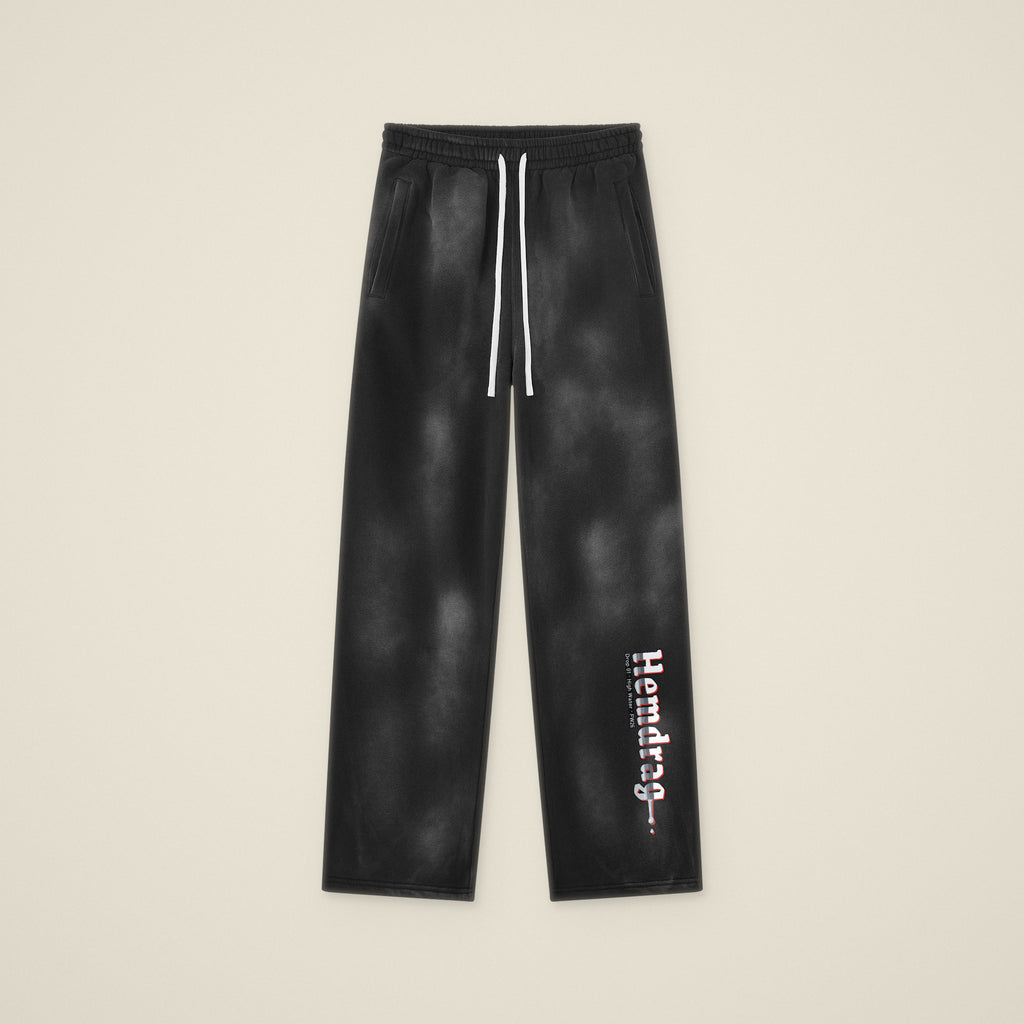 Digital preview: the Hemdrag sweatpants laid flat, front view, with Hemdrag printed down the left lower leg only. The print was added digitally to a photo of the blank pants.